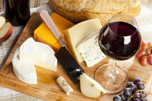 close up picture of cheese with a glass of wine